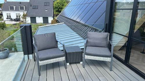 two chairs on a deck with a view of a house at Suite Ouddorp - 2 pers in Ouddorp