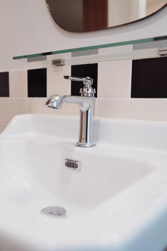 a white bathroom sink with a chrome faucet at LALA Hôtel in Paris