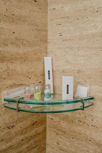a glass shelf on a wall with candles on it at Stay Studio Hotel & Residences in Gurgaon