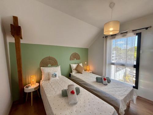 deux lits jumeaux dans une chambre avec fenêtre dans l'établissement La Maison Ty Isalain, à Clohars-Carnoët