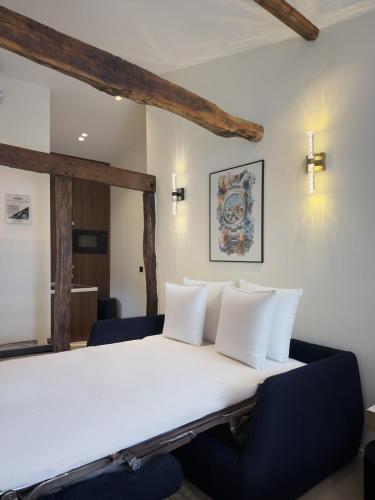 un lit avec des draps blancs et des oreillers dans une chambre dans l'établissement Luxury Suite, Montaigne & Champs Elysées, à Paris