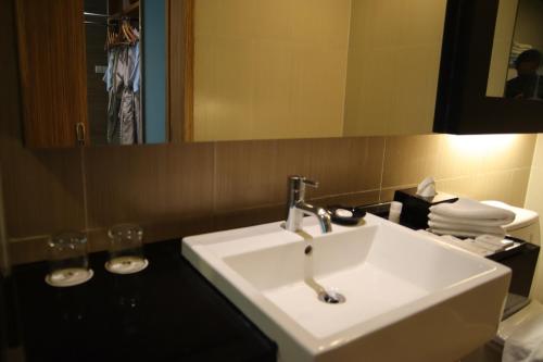 a bathroom with a white sink and a mirror at The Klagan Hotel in Kota Kinabalu