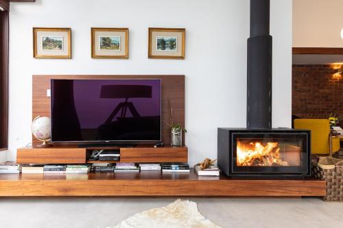 a living room with a tv and a fireplace at Casa de Neiva in Esposende