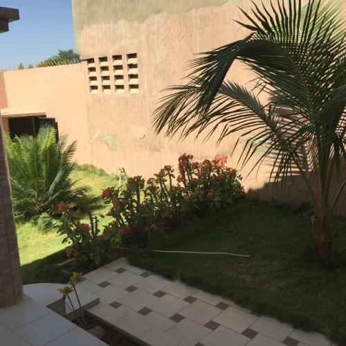 a house with a palm tree in front of a yard at Villa Savana in Saly Portudal