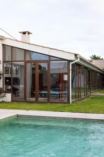 a house with glass windows and a swimming pool at Casa de Neiva in Esposende