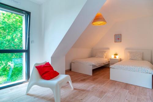 une chambre avec deux lits et une chaise et une fenêtre dans l'établissement Parenthèse Iodée - 7min à Pied de la Plage, à Bénodet
