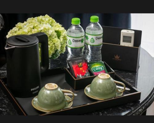 un vassoio con 2 bottiglie d'acqua e 2 teiere di Downtown VangVieng Hotel a Vang Vieng