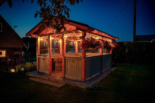 a small house with lights in a yard at night at Domki u Rybaka in Kąty Rybackie