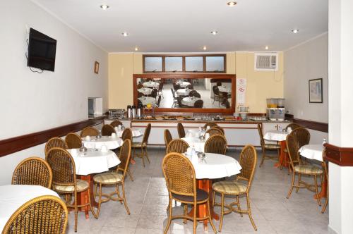 un comedor con mesas y sillas blancas en Villas Boas Hotel, en Campinas