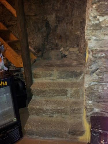a stone staircase in a room with a stone wall at Su Cuccumeu in Seui