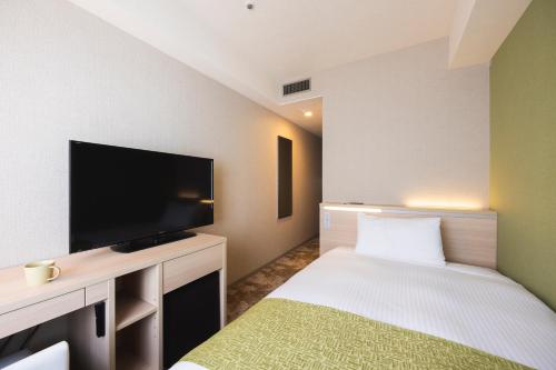 a hotel room with a bed and a flat screen tv at Shinjuku Washington Hotel Annex in Tokyo