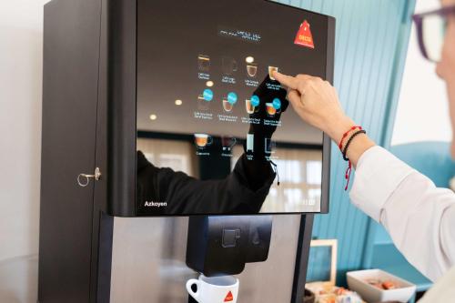 a person is taking a picture of a vending machine at Hotel Planas in Salou