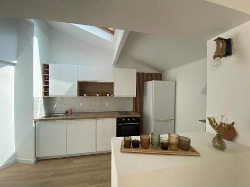 une cuisine avec des armoires blanches et un réfrigérateur blanc dans l'établissement Calanque de Samena, à Marseille