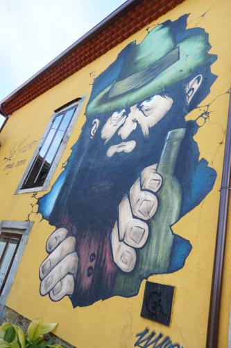 a mural of a man holding a bottle of wine at La Casona de Faedo Pensión in Faedo
