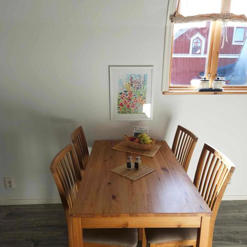 a wooden dining room table with chairs and a bowl of fruit at Historical area, Nature, cozy and comfortable in Skruv