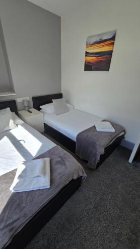 a room with two beds and a painting on the wall at Y Gwynedd Inn in Llanberis