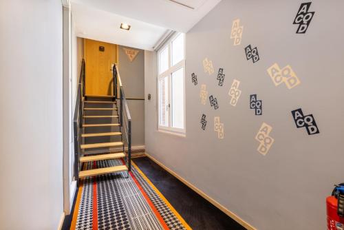 a hallway with stairs and signs on the wall at Au Chat Qui Dort Lille - Thiers in Lille