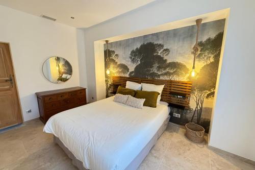 une chambre avec un lit blanc et un tableau au mur dans l'établissement Superb Mas provençal - swimming pool - tennis - park, à LʼIsle-sur-la-Sorgue