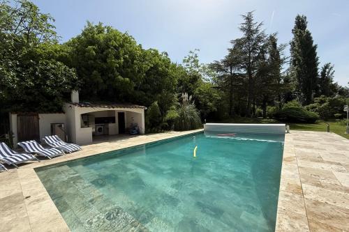 une piscine avec de l'eau bleue dans une cour dans l'établissement Superb Mas provençal - swimming pool - tennis - park, à LʼIsle-sur-la-Sorgue