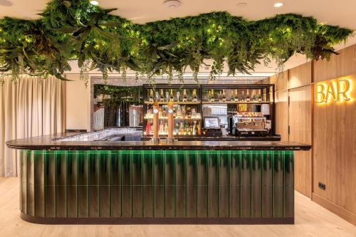 a bar in a restaurant with a green counter at Hotel Murcia Rincón de Pepe Affiliated by Meliá in Murcia
