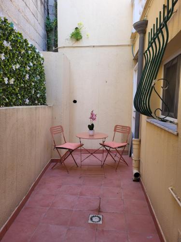 - une petite terrasse avec 2 chaises et une table dans l'établissement Studio haut de gamme, à Nice