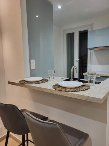 - un comptoir de cuisine avec 2 chaises et un évier dans l'établissement Studio haut de gamme, à Nice