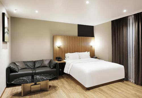 a hotel room with a bed and a couch at Seosan Mari Hotel in Seosan