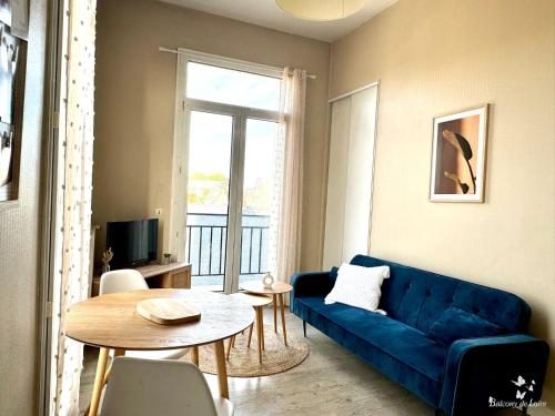 un salon avec un canapé bleu et une table dans l'établissement Appartements Balcony de Loire, à Tours