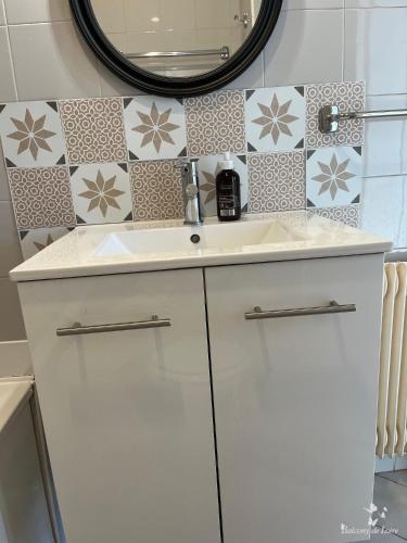 une salle de bain avec un lavabo blanc et un miroir dans l'établissement Appartements Balcony de Loire, à Tours