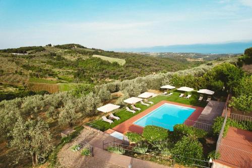 an aerial view of a villa with a swimming pool and umbrellas at Relais Villa Olmo - Place of Charme in Impruneta