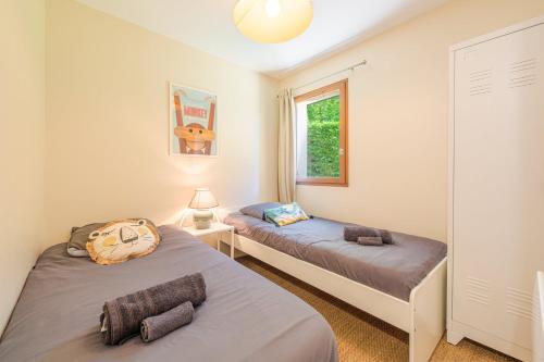 une chambre avec deux lits et une fenêtre dans l'établissement La Coquille / F3 de charme avec jardin privatif, à Cabourg