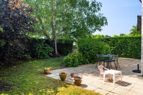 un patio avec une table et des chaises dans une cour dans l'établissement La Coquille / F3 de charme avec jardin privatif, à Cabourg
