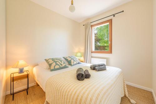 une chambre avec un lit avec deux paires de chaussures dessus dans l'établissement La Coquille / F3 de charme avec jardin privatif, à Cabourg