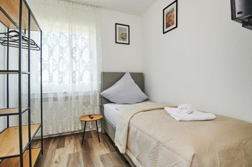 a small bedroom with a bed and a window at RG Living - Pro Comfort in Herford