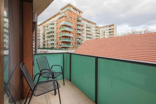 two chairs sitting on the balcony of a apartment at Escala Hotel & Suites in Budapest