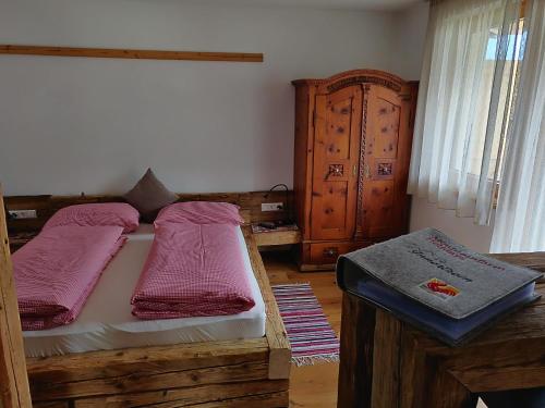 a bedroom with a bed with pink pillows on it at Innertrein in Cadipietra