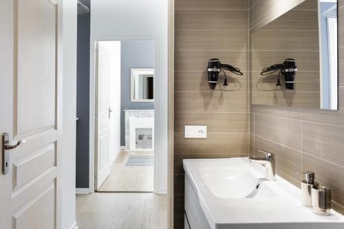 une salle de bain avec un lavabo et une baignoire dans l'établissement Bourgeois apartment with sea view, à Nice