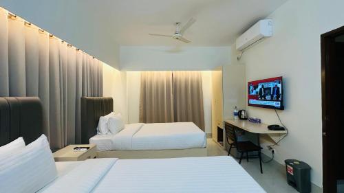Кровать или кровати в номере Royal Regent Suites Dhaka