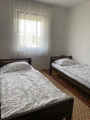 two beds in a room with a window at Apartman Fad in Bihać