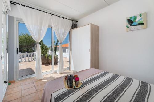 a bedroom with a bed and a large window at Villa Milena in Callao Salvaje