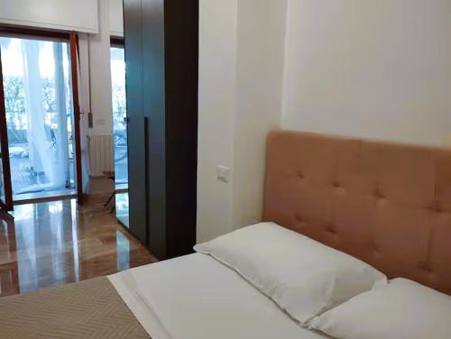 a bedroom with a bed with a headboard and a window at Residence MareVerde in Senigallia
