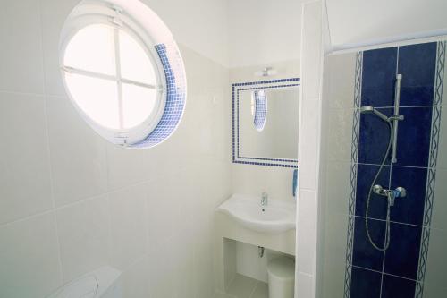 a white bathroom with a sink and a mirror at Aquilo Apartmanok in Tihany
