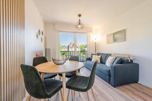 un salon avec un canapé bleu, une table et des chaises dans l'établissement L'Opaline - F2 pour 4Pers / Houlgate, à Houlgate