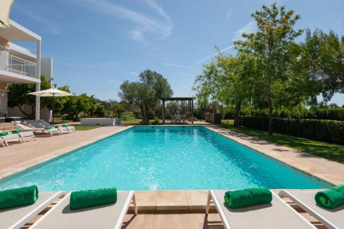 a swimming pool with chaise lounges in a backyard at New! Villa Margarita - Ibiza in Santa Eularia des Riu