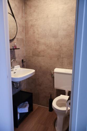 a bathroom with a white toilet and a sink at Hotel de Abdij in Horn