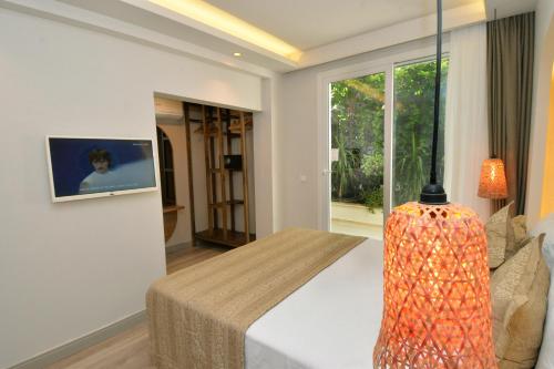 a bedroom with a bed and a lamp and a window at IDEE SUİTES Fethiye in Fethiye