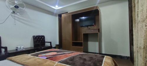 a bedroom with a bed and a tv on a wall at The Miadam Hotel in Swat