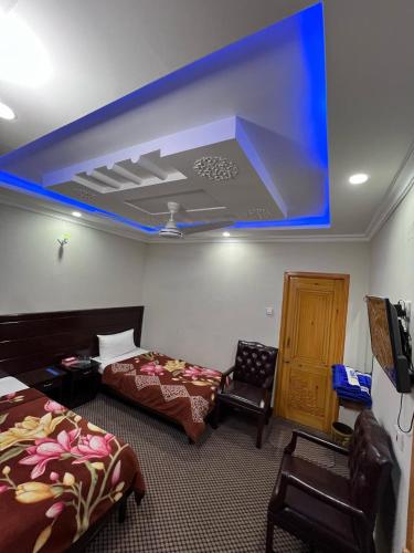 a room with two beds and a blue ceiling at The Miadam Hotel in Swat