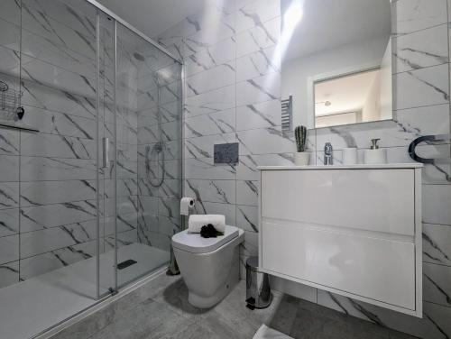 Un baño blanco con inodoro y ducha. en Xava Dreams Aire, en Villacosta