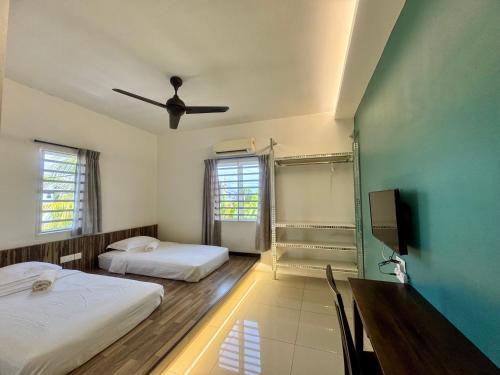 a bedroom with two beds and a ceiling fan at Lavender house IPOH in Ipoh